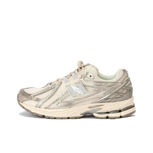 Medial side view profile of cream and metallic silver New Balance running shoes