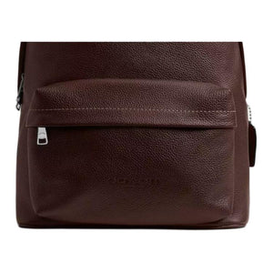 Close-up view of the front zipped pocket and embossed logo on an authentic Coach Westway 32 dark burgundy leather backpack.
عرض قريب للجيب الأمامي ذي السحاب والشعار البارز على حقيبة ظهر كوتش ويست واي 32 أصلية جلد باللون العنابي الداكن.