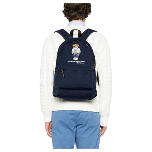 Back view of a man wearing an authentic Ralph Lauren Polo Bear navy backpack, perfect for back-to-school style and everyday use.
عرض من الخلف لرجل يرتدي حقيبة ظهر Ralph Lauren Polo Bear باللون الكحلي أصلية، مثالية لأسلوب العودة للمدرسة والاستخدام اليومي