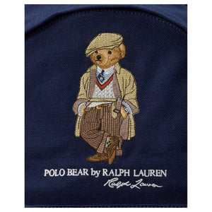 Detailed close-up of the signature embroidered Polo Bear and printed Ralph Lauren logo on an authentic navy blue backpack.
لقطة قريبة مكبرة لتطريز دب بولو الشهير وشعار رالف لورين المطبوع على حقيبة ظهر كحلي أصلية.