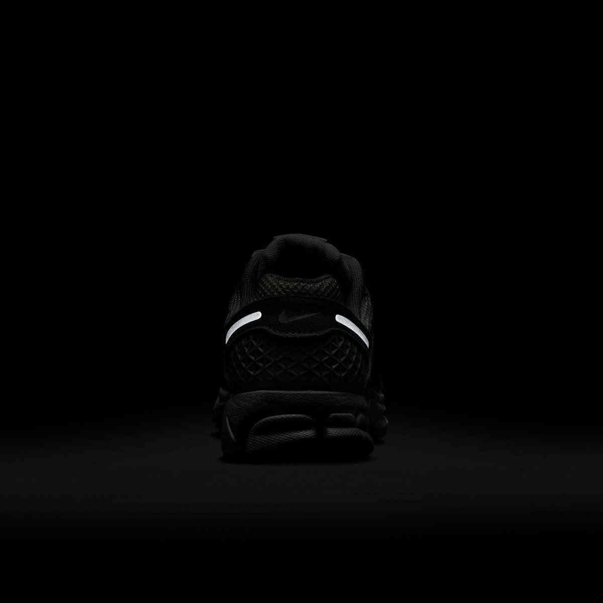 حذاء رياضي Nike Vomero 5 رمادي فاتح بتفاصيل عاكسة.