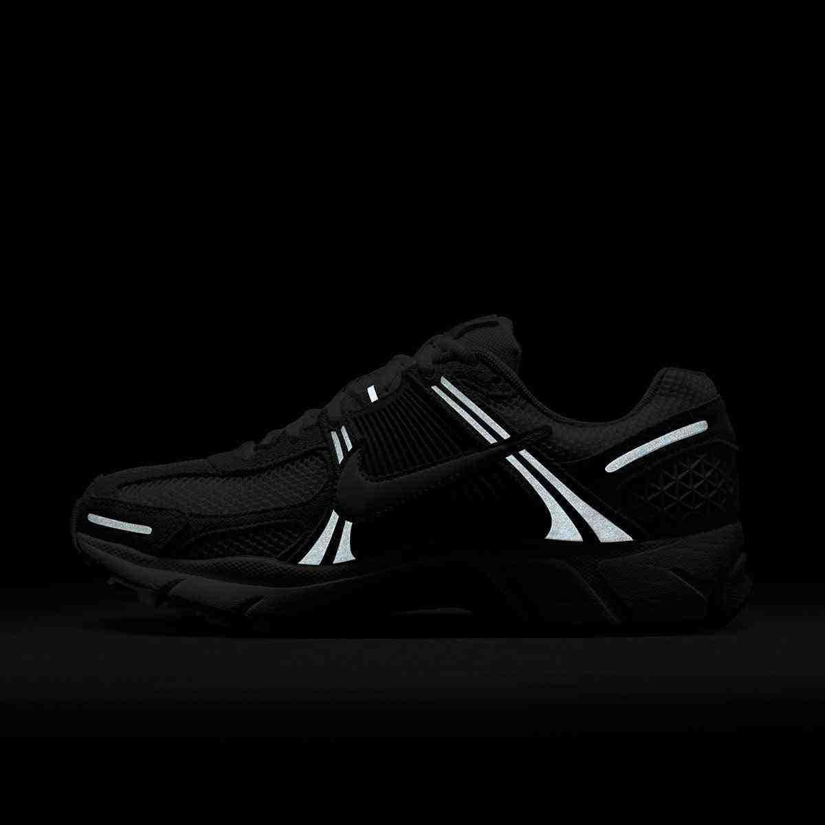 حذاء رياضي Nike Vomero 5 رمادي فاتح بتفاصيل عاكسة.