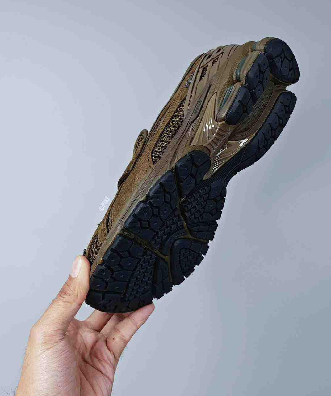 Lateral hand-held view of the New Balance 1906L Dark Olive demonstrating the smart-casual style.