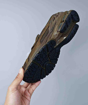 Lateral hand-held view of the New Balance 1906L Dark Olive demonstrating the smart-casual style.