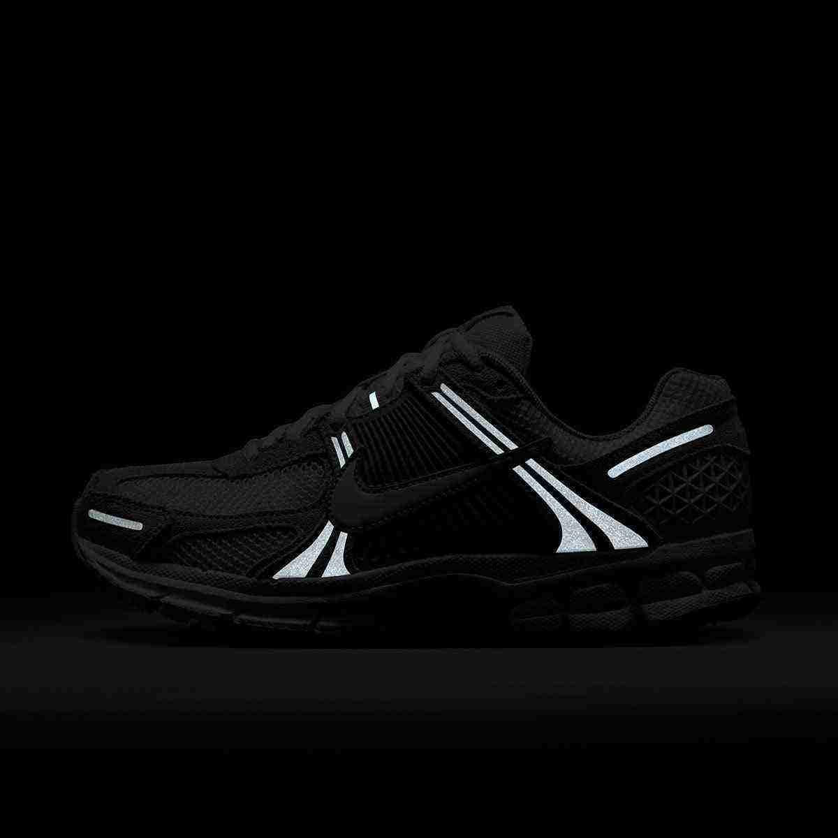 حذاء رياضي Nike Vomero 5 رمادي فاتح بتفاصيل عاكسة.