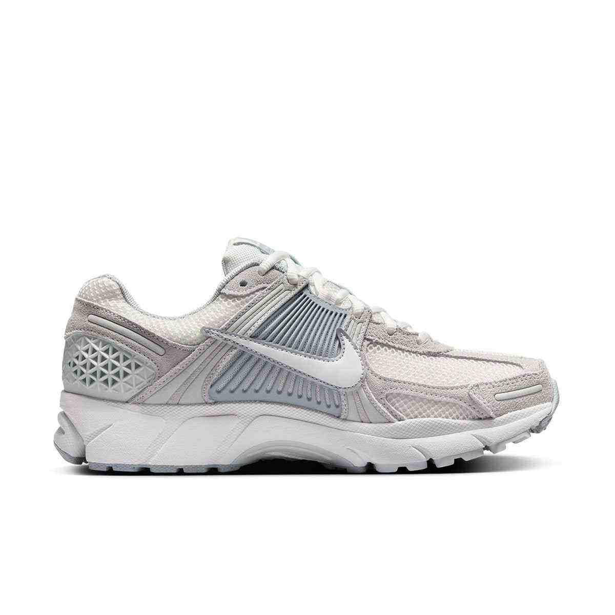 حذاء رياضي Nike Vomero 5 رمادي فاتح بتفاصيل عاكسة.