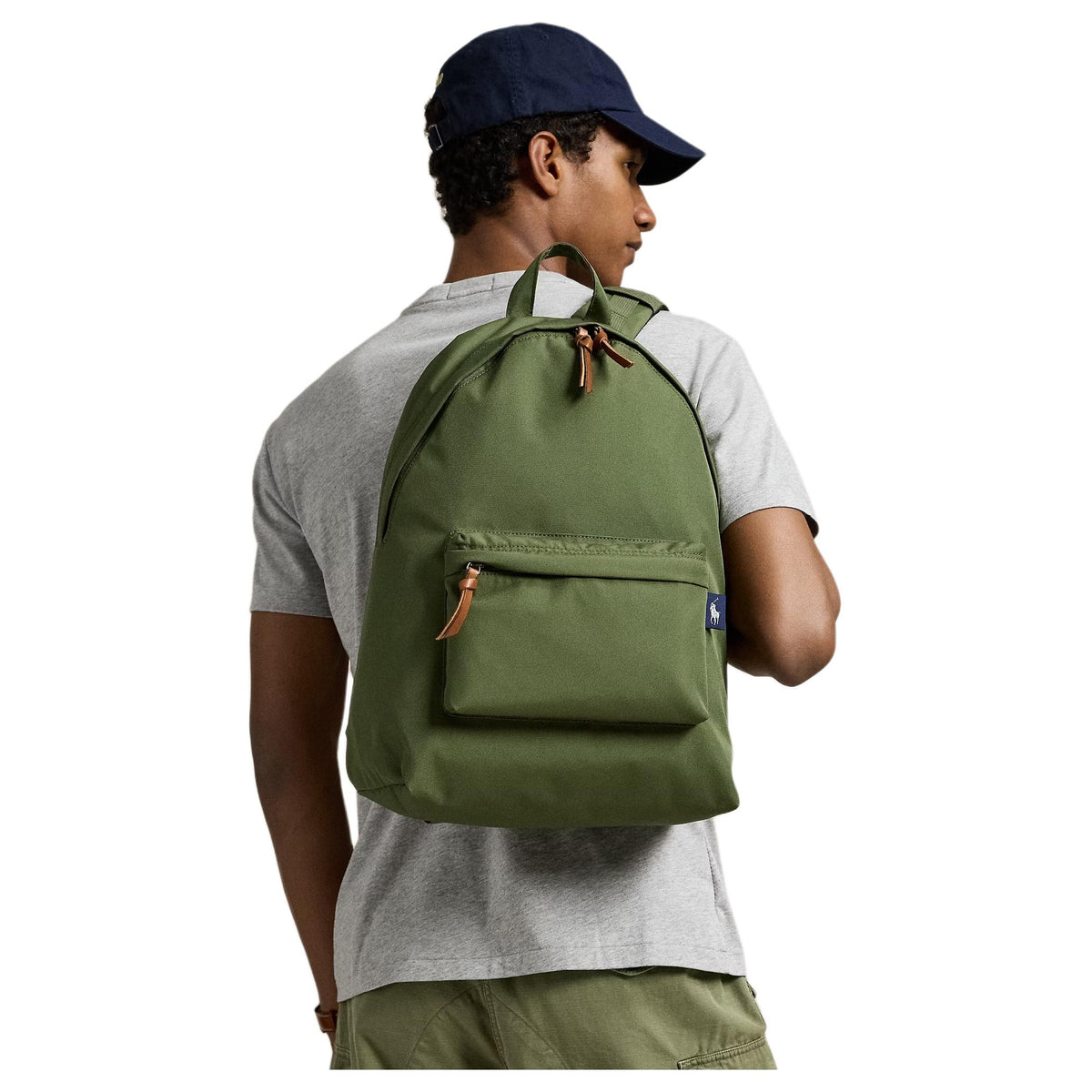 A man wearing an authentic Polo Ralph Lauren olive green backpack, perfect for back-to-school style and casual outfits.

رجل يرتدي حقيبة ظهر Polo Ralph Lauren أصلية باللون الأخضر الزيتوني، مثالية لأسلوب العودة للمدرسة والإطلالات اليومية.
